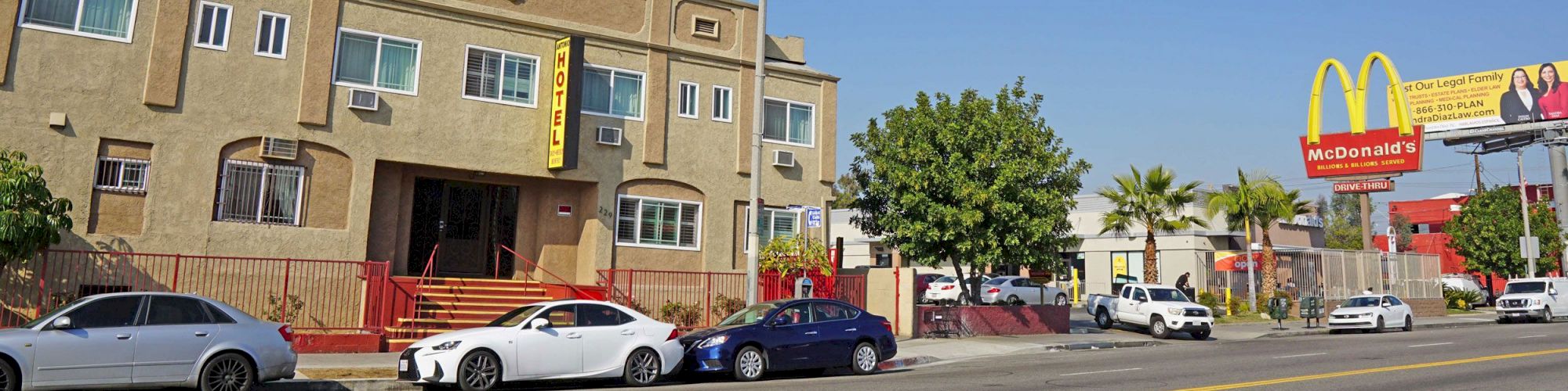 The image shows cars parked in front of a multi-story building labeled 