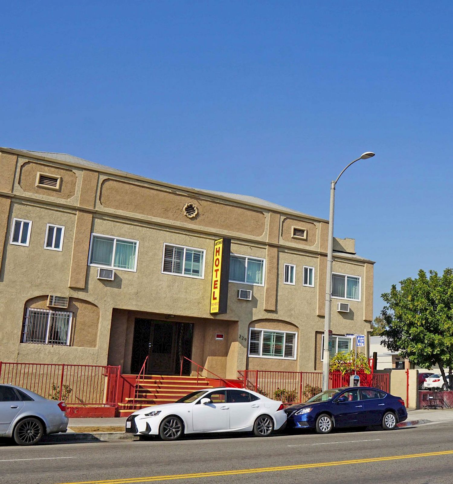 A street scene with several cars, a building, and a McDonald's billboard is visible in the background, with a clear blue sky overhead.